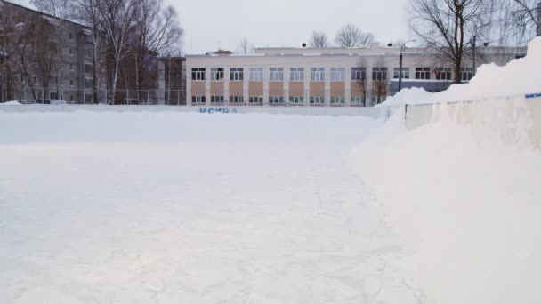 Kleine jongen in gele snowsuit skates en valt op snowdrift — Stockvideo
