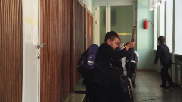 Niño con equipo de hockey golpeado por la puerta en el pasillo de la escuela — Vídeos de Stock