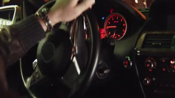 Jonge man rijdt auto langs City Street bij nacht close-up — Stockvideo