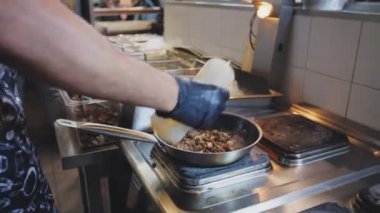 adam ete yağ katıyor ve kafede yemek hazırlayan ateşi yakıyor