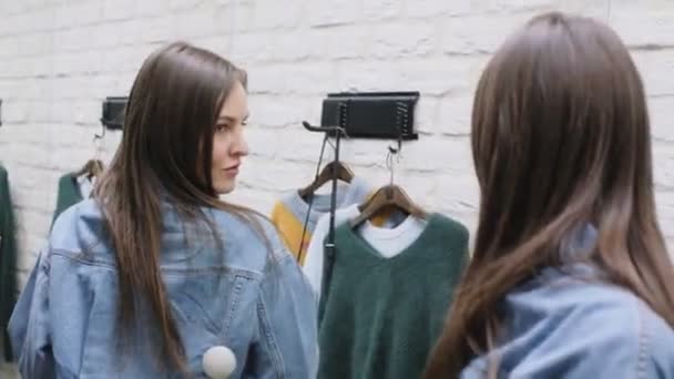Брюнетка дівчина намагається на стильний короткий піджак Джинсовий на дзеркало — стокове відео