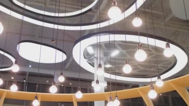 Лампочки висят под потолком торгового центра со свинцовыми лампами — стоковое видео