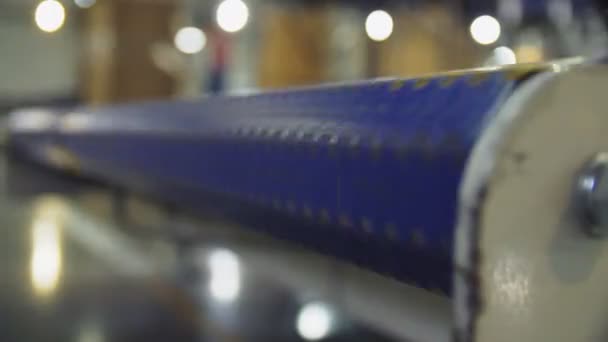 Parte azul de la línea de producción contra cajas de cartón borrosas — Vídeo de stock