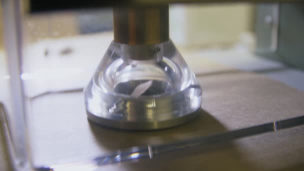 Přístroj vyrábí otvory v hnědém lepenkovém plechu se skleněnou částí — Stock video