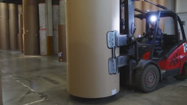 Forklift loader puts huge roll of paper on pile in storage — Stock Video
