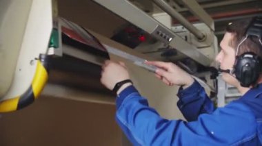 genç işçi üretim hattında kağıt levha kenarı keser