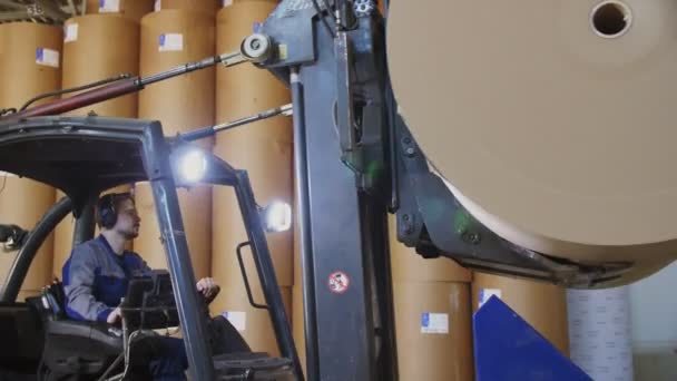 Man drives heftruck loader tillen papierrol in workshop — Stockvideo