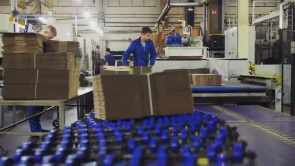 Kartonnen blokken op transportband onder werknemers controle in winkel — Stockvideo