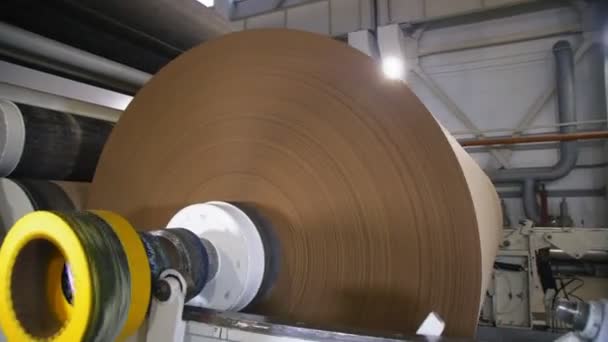 Mechanism reels packaging paper on huge roll at plant — Stock Video