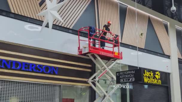 Работник устанавливает деревянные доски на фасад магазина — стоковое видео