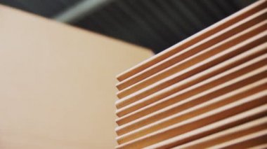 işçi atölyede kazık üzerine katlanmış karton kağıt koyar