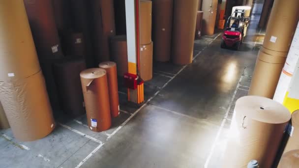 Погрузчик несет бумажный рулон по перевалу на складе — стоковое видео