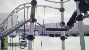 kapaklı küçük kız baba yardımı ile oyun alanında tırmanıyor