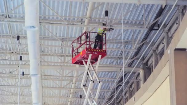 Werknemer installeert feestelijke decoraties onder plafond timelapse — Stockvideo