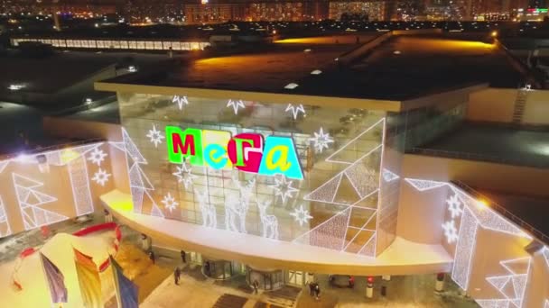 Торговый центр с логотипом MEGA и симпатичным оленем в зимнюю ночь — стоковое видео