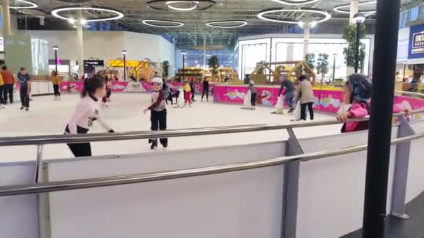 Niños patinan en la arena de hielo pasando tiempo en el centro comercial — Vídeos de Stock