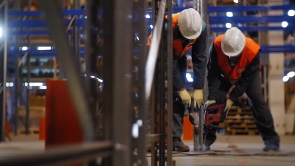 Trabajadores en cascos fijan la carcasa del estante en la cámara lenta del almacén — Vídeo de stock