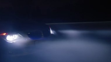 Işıklı otomobil kış gecelerinde yol boyunca yol alır.