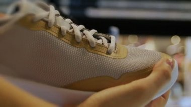 Spor ayakkabılı bir müşteri ve moda mağazasında çift sohbeti.