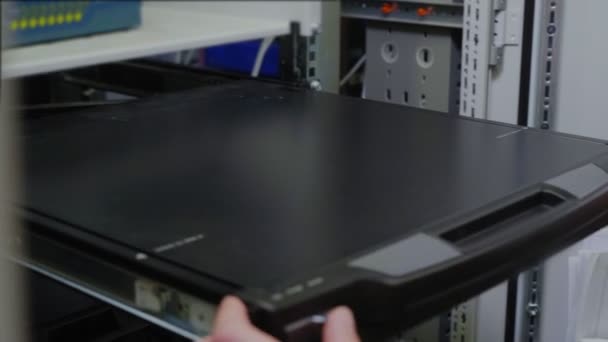 Technicus neemt laptop en controles systeem in serverruimte — Stockvideo