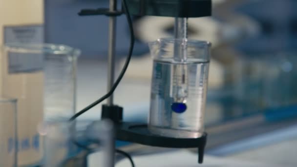 Bécher avec liquide dans le dispositif d'essai en gros plan de laboratoire — Video