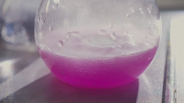 Frasco de florência com líquido roxo na mesa em laboratório — Vídeo de Stock