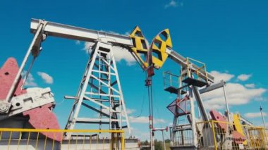 pompa hırsızları güneşli bir günde mavi gökyüzüne karşı petrol sahasında çalışır