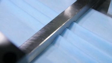 otomatik makine maske mavi malzeme üzerinde kıvrımlar oluşturur