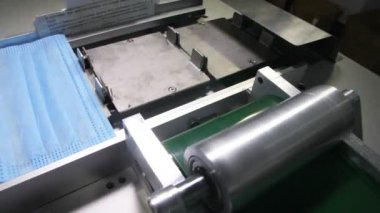 Taşıyıcı, maskeler için kumaş çarşafları üretim hattına koyar