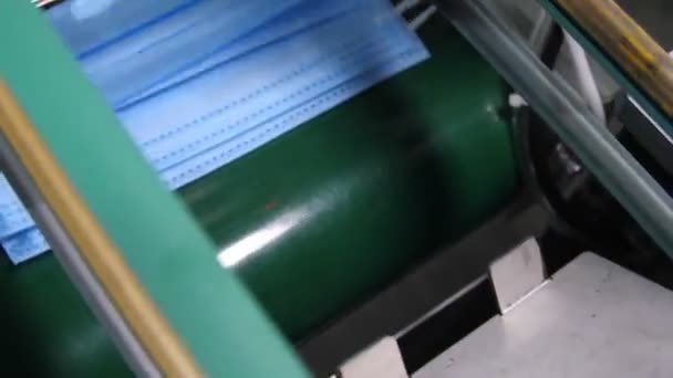 Конвейер складывает готовые медицинские маски в стопку — стоковое видео