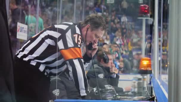 Hockey judge talks on phone in operators cabin near arena — Stock Video