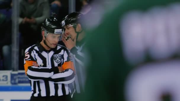 Juge en casque parle à un collègue sur la patinoire au match — Video