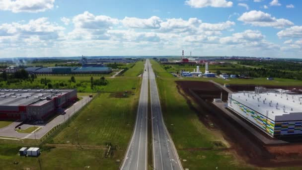 Motorväg med rund korsning och produktionskomplex i fält — Stockvideo