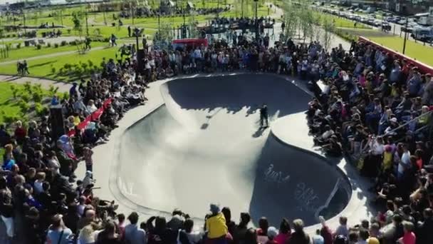 Sporter doet trucs op skateboard in groot zwembad in park — Stockvideo