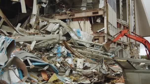 Escavadeira com balde desmonta detritos no local de demolição — Vídeo de Stock