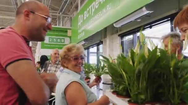 Verkoopster geeft verse planten aan klanten in supermarkt — Stockvideo