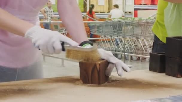 Žena leští dřevěný blok s kovovým štětcem u stolu — Stock video
