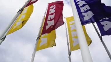 Ikea bayrakları baharda bulutlu gökyüzüne karşı rüzgarla dalgalanır