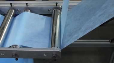 Üretim hattındaki maskeler için açık mavi malzeme şeritleri