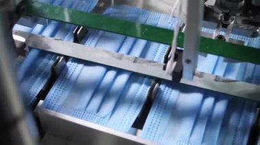 Basın makinesi elastik bandı mavi koruyucu maskelere bağlıyor