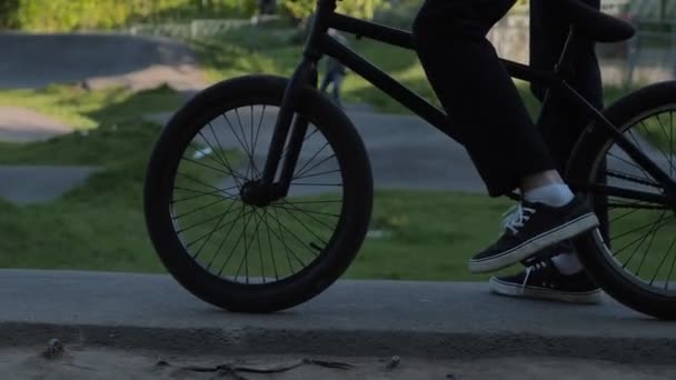 Personne en gomme promenades vélo passé spirea buisson dans le jardin — Video