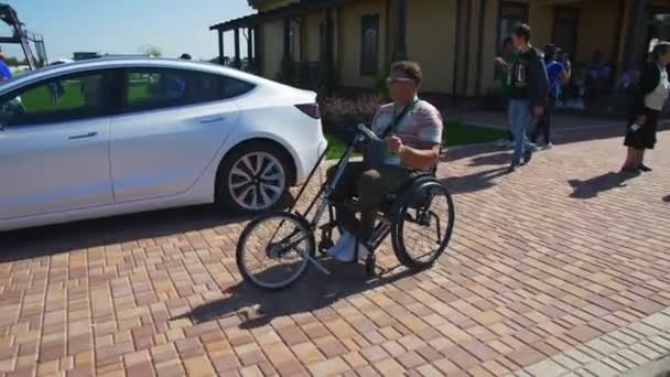 Mężczyzna na wózku inwalidzkim jeździ obok samochodu i Skyway transportu — Wideo stockowe