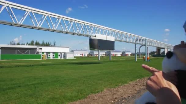 Madre muestra unicar conducción a lo largo de la suspensión de ferrocarril a chica — Vídeos de Stock