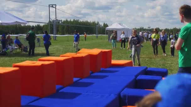 Vrolijk meisje loopt en springt op sportveld met zachte kubussen — Stockvideo