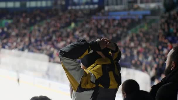 Chlapec v bundě hodinky hokejový zápas z diváckého místa — Stock video