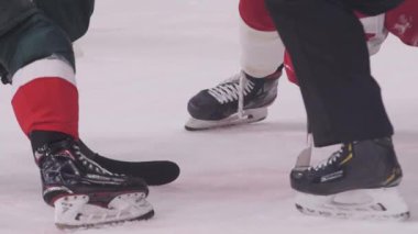 Hokey takımı katılımcıları modern buz pateni pistinde puck için mücadele ediyor