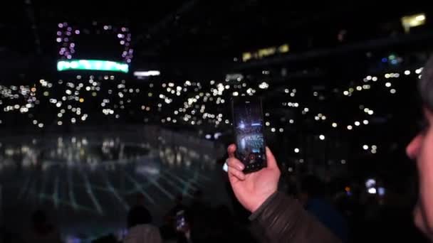 Man shots fantastic laser show on ice rink at winter night — Stock Video