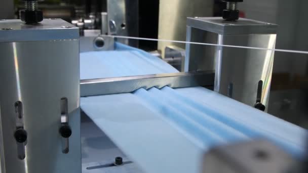 Machine draagt stof en elastische band om maskers te vervaardigen — Stockvideo