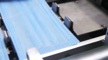 Makine koruyucu maskeler için hazır çarşafları taşıyıcıya koyar
