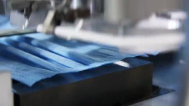Üretim hattı elastik bantları tek kullanımlık maskelere bağlıyor